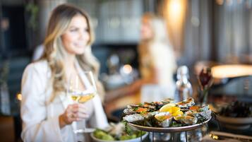 A dining table with a seafood platter and a bottle of wine.