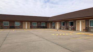 A motel with a central courtyard, numbered rooms, and outdoor seating.