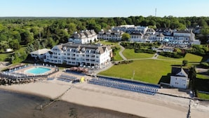 A resort with multiple buildings, a swimming pool, and a beach area.