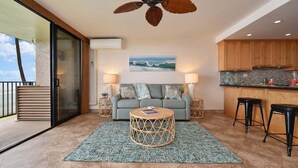 A modern living room with a sofa, a round coffee table, and a ceiling fan.
