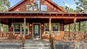 A wooden cabin with a porch, large windows, and a satellite dish. - Secluded Log Cabin, Mountain Top, Hot Tub, Pool Table, 5 Miles From Downtown (Hot Springs)