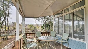 A covered outdoor seating area with a round table and chairs, overlooking a natural landscape. - Fishing Paradise w/ Deck On Suwannee River (Branford)