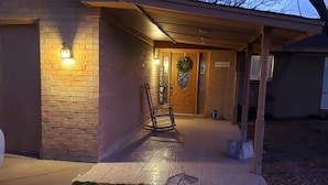 Un bâtiment à la façade en briques, une porte en bois ornée d’une guirlande et une enseigne sur laquelle on peut lire « BIENVENUE ».