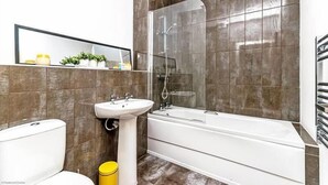 A modern bathroom with a bathtub, a sink, and a toilet.
