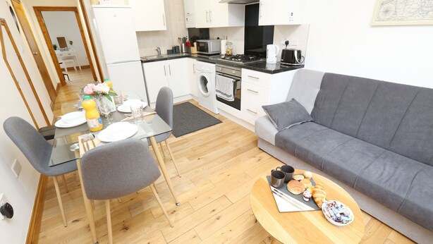 A compact living space with a dining area, kitchenette, and seating area.