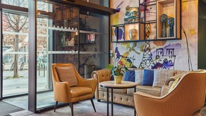 A modern interior with a leather sofa, a round table, and a bookshelf with decorative items.