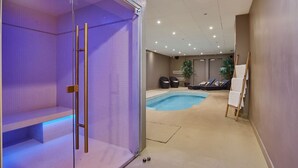 A modern spa area with a pool, seating, and a glass-enclosed sauna.