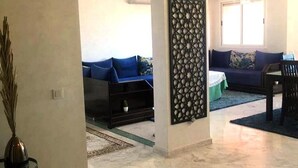 Una sala de estar con sofá, mesa de centro y un panel decorativo en la pared.