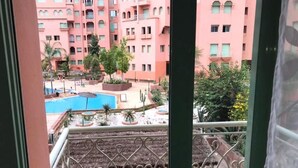 A view of a pink building with a pool and landscaped garden. - Residence Atlas Marrakech 4680 (Marrakech)