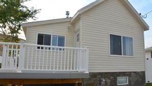 A two-story mobile home with a front deck and a small attached garage.
