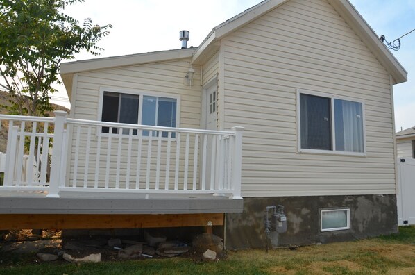 A two-story mobile home with a front deck and a small attached garage.