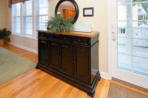 A dark wooden cabinet with a mirror above it, a potted plant on top, and a sign that reads "gift of the beach." - 6 BR Beach House with a Private Pool Beach House! Joye-Phil Times (Surfside Beach)