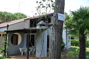 A two-story building with a covered patio area, a round window, and a sign indicating a restaurant. - villa SILVANA - Lignano Riviera (Lignano Sabbiadoro)