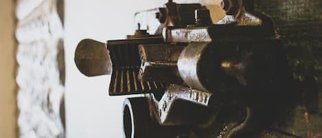 Primer plano de un dispositivo mecánico, posiblemente una válvula o bomba, con cuerpo cilíndrico y una palanca sobresaliente.