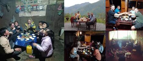A rustic dining area with a wooden table and chairs, surrounded by a mountainous landscape.