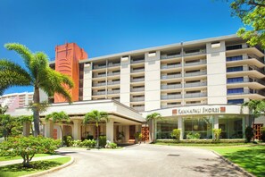 A modern mid-rise property featuring tropical landscaping, palm trees, and a welcoming entrance set against clear blue skies in a resort-style setting. - Aston Ka'anapali Shores 325 | Lush Garden Views – Pool, Hot Tub & Spa (Lahaina)