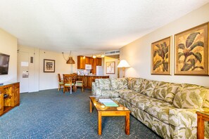 Une chambre d’hôtel comprenant un coin salon, une kitchenette et un espace repas.