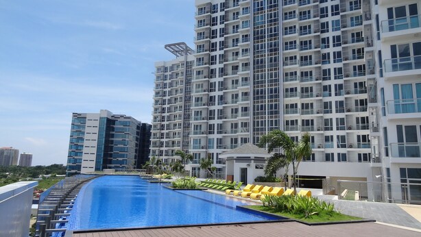 Un edificio residencial moderno con piscina y tumbonas.