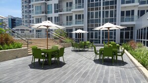 Una terraza en la azotea con mobiliario exterior y una escalera que lleva a un nivel superior.