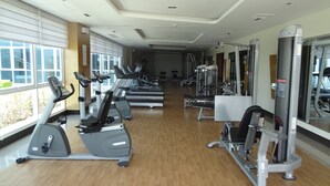 Un gimnasio con cintas de correr, elípticas y máquinas de pesas.