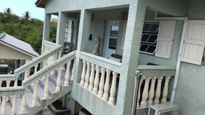 Un edificio de varios niveles con escaleras, balcones y una puerta con ventanal.