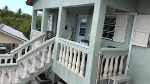 Two-story building with a balcony and staircase, offering a simple, functional design.