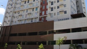 Un edificio de gran altura con varios pisos, balcones y una sección central roja.