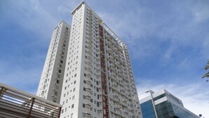 Ein Hochhaus mit mehreren Etagen, Balkonen und einem modernen architektonischen Design.