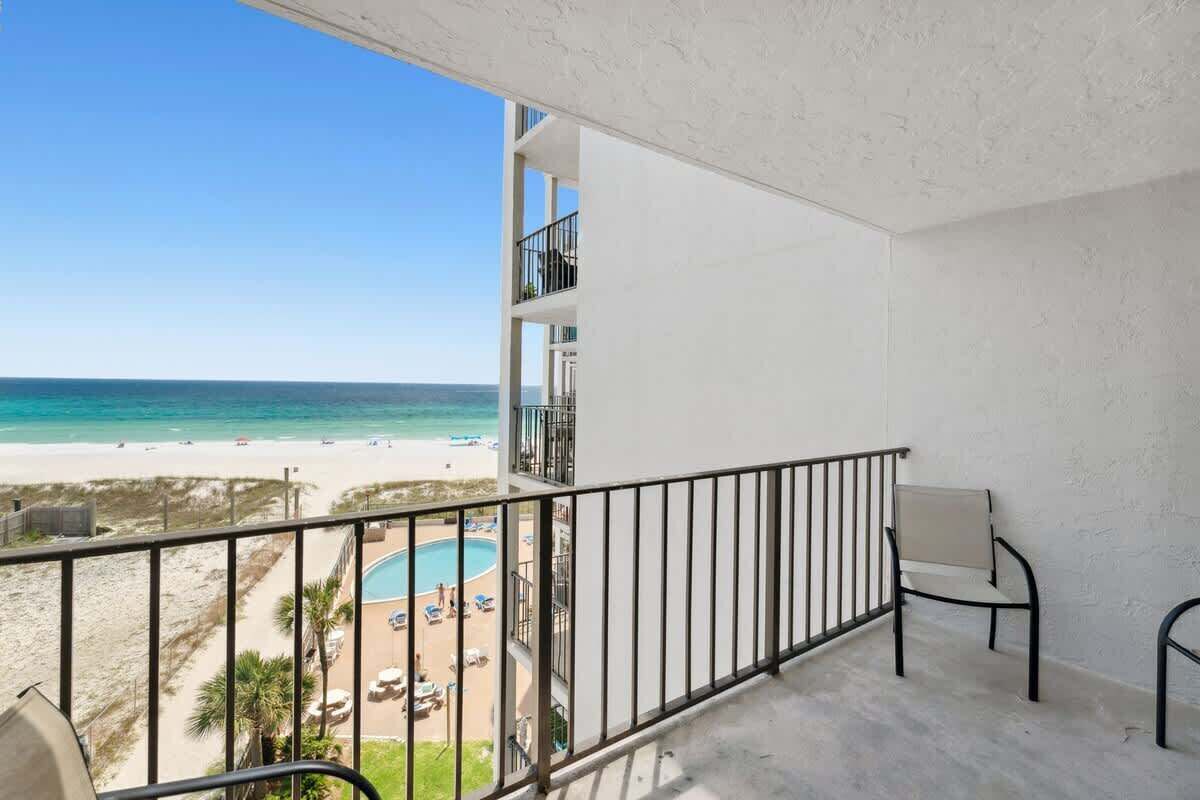 Un balcon avec vue sur la plage et la piscine.