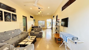 A living room with a sofa, armchairs, a coffee table, a TV, and a small table with a striped tablecloth. - Midsummer Thulusdhoo (Thulusdhoo Island)