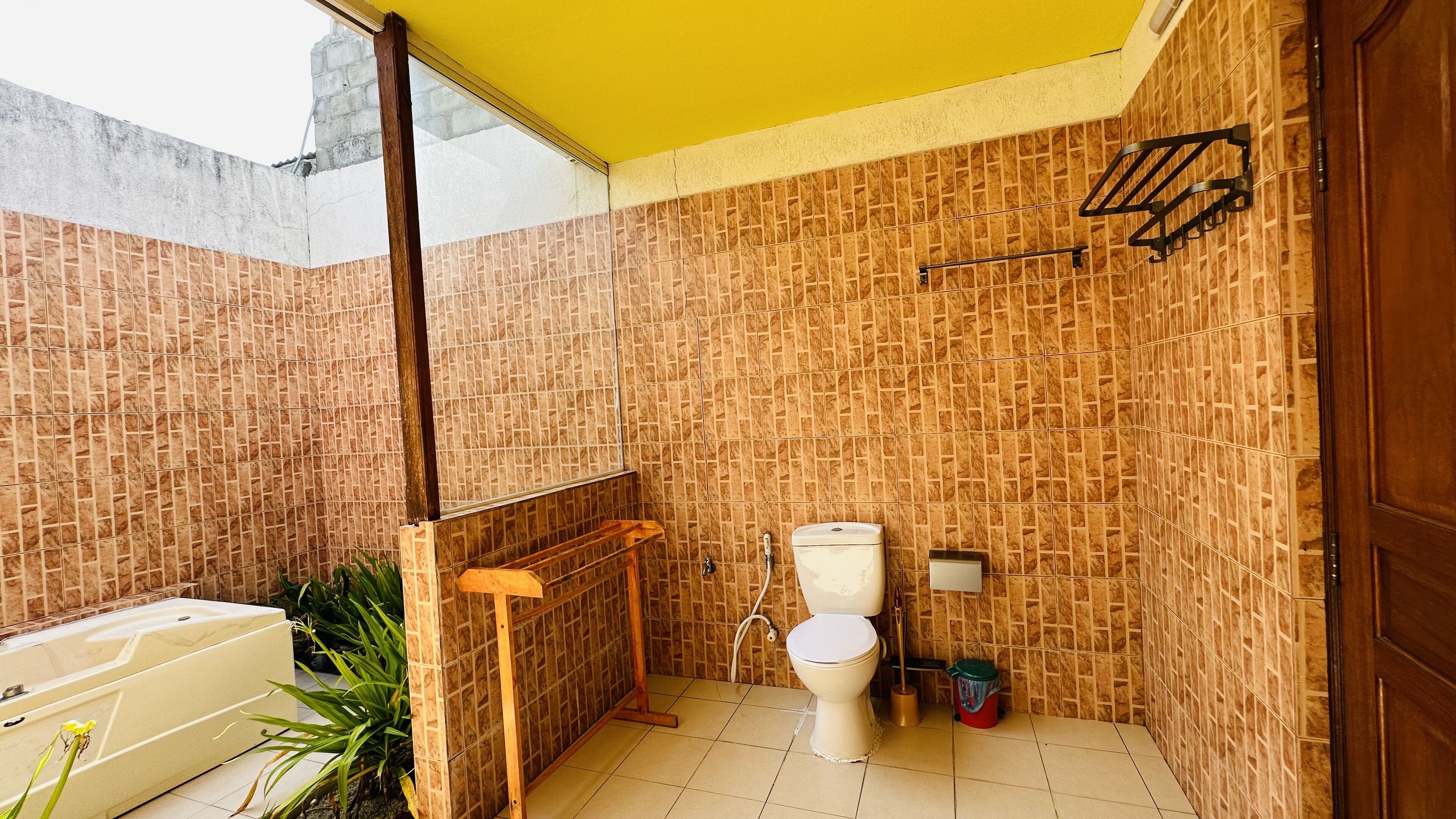 A small bathroom with a toilet, a shower area, and a bathtub.