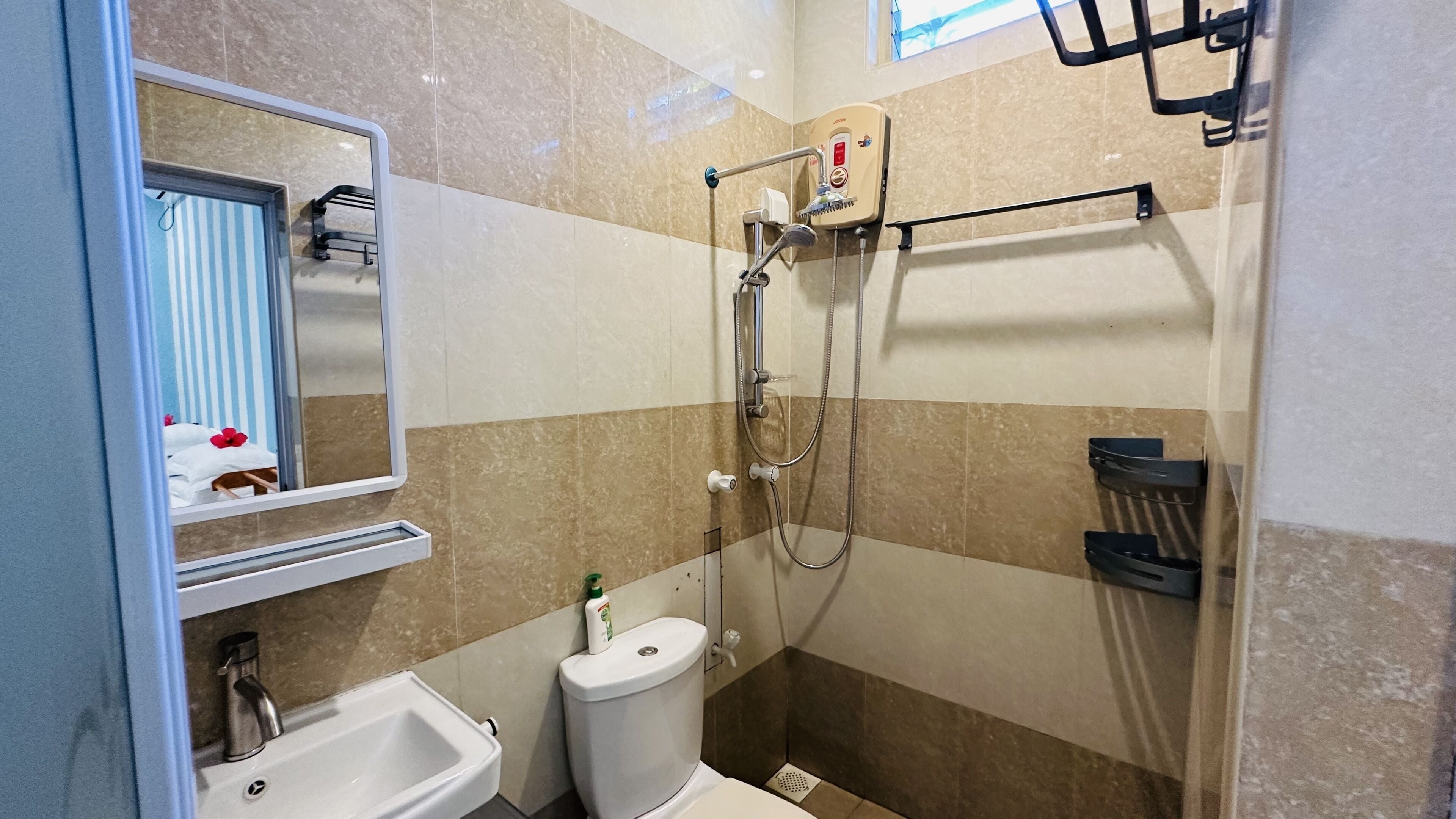 A modern bathroom with a shower, toilet, sink, and a mirror.