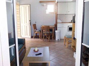 A compact living space with a dining area, kitchenette, and a small seating area with a table and chairs.