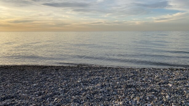 A pebbled beach with a calm sea and a cloudy sky. - Good apartment 300 m from Black sea (Batumi)