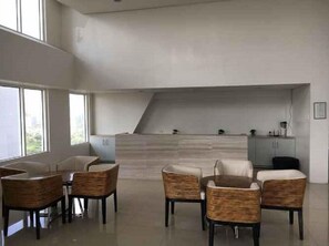 Uma cozinha moderna com fogão embutido, área de refeições com cadeiras de vime e vista para o verde lá fora.