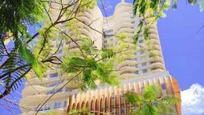 Een hoog gebouw met een modern ontwerp, met verticale lijnen en balkons.