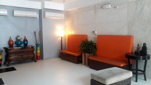 A modern waiting area with a sofa, a small table, and a decorative cabinet. - City Suites Ramos Tower (Cebu City)