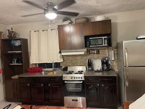 Enjoy cooking in this well-equipped kitchen with a gas stove, refrigerator, and microwave.