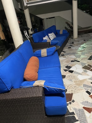 Relax in the outdoor seating area with a sofa and wicker chair.