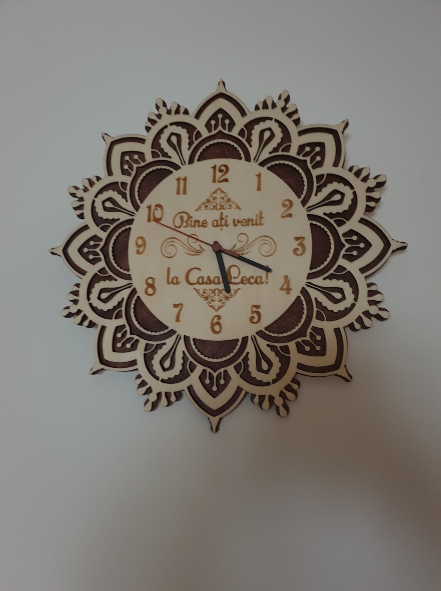 Un reloj de pared decorativo con diseños intrincados y el texto "la Casa Loca!"