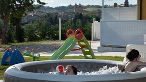 Piscina al aire libre con vista a un pueblo en el fondo.