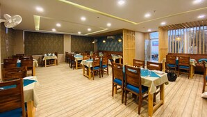 Un restaurant spacieux doté d’un plancher en bois, de nombreuses tables et chaises, et d’une grande fenêtre laissant entrer la lumière naturelle.