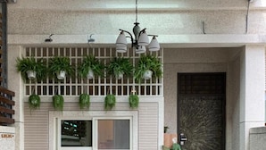 A conference room with a wooden table, black chairs, a bench, and potted plants. - 910 Hostel (Yuli)