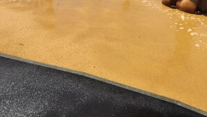Un área de juegos acuáticos con piscina y toboganes, rodeada de bancos y un parque infantil.