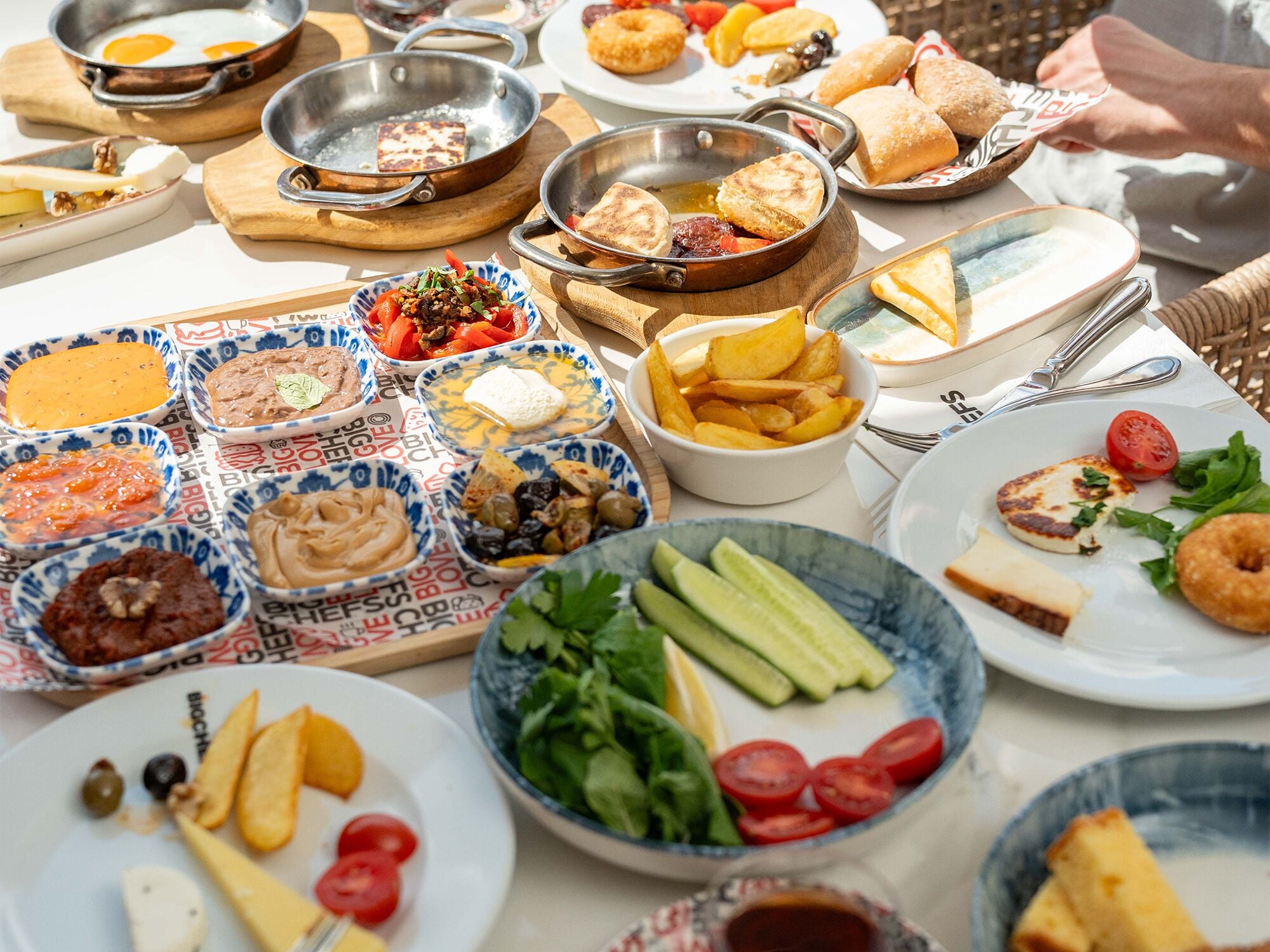 Una variedad de platillos sobre una mesa, incluyendo pan, queso y verduras.