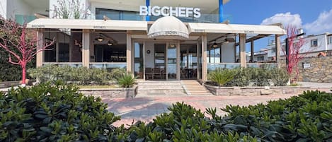 A modern building with a sign reading "BIGCHEFS" and "BEACH HOTEL" above the entrance.