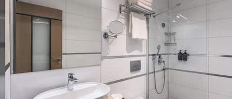 Un baño moderno con un lavamanos grande, un inodoro, una ducha y un espejo.