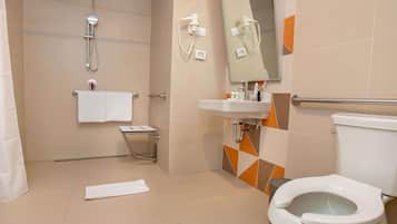 Un baño moderno con ducha, inodoro, lavabo y un pequeño taburete.