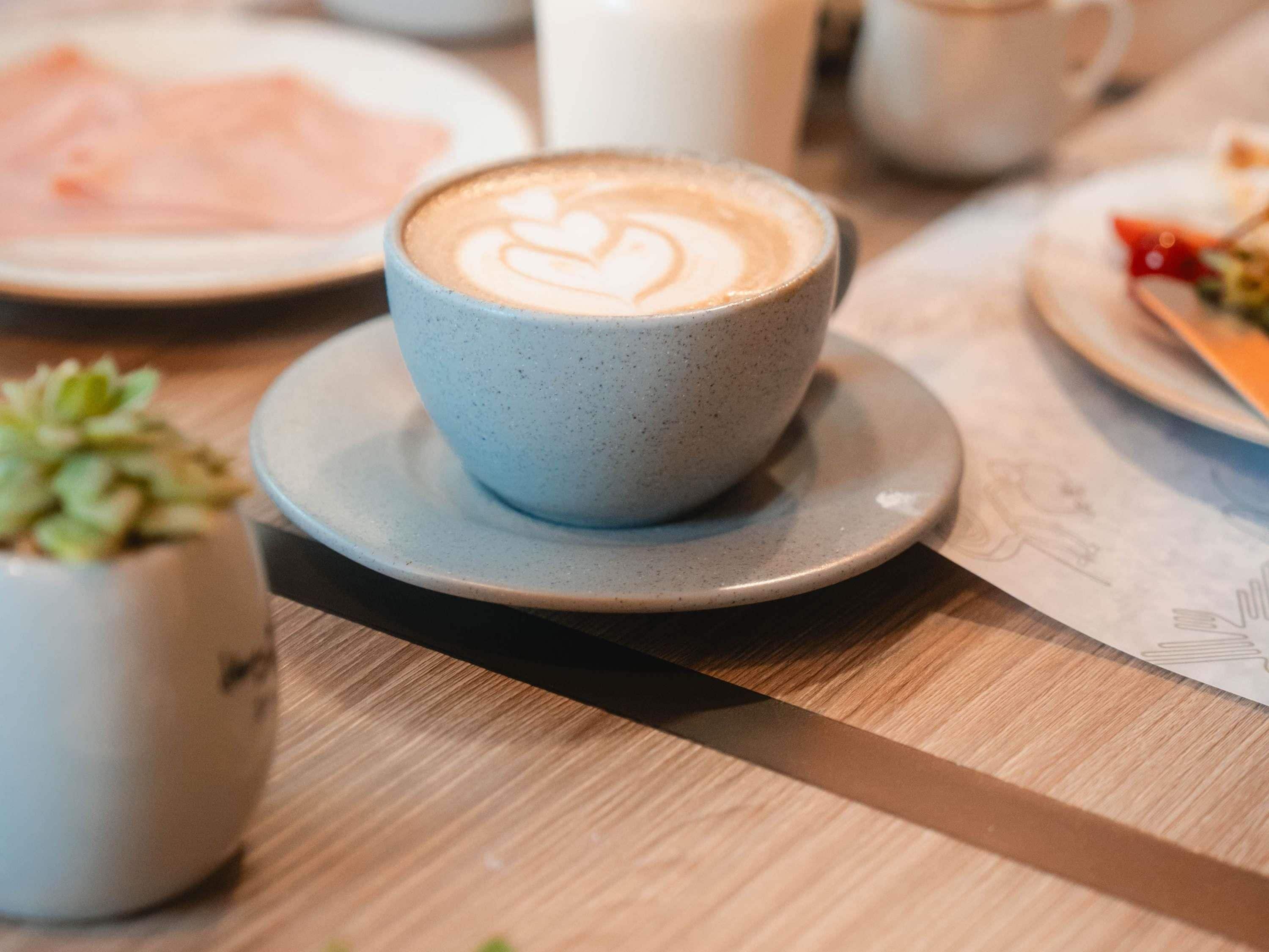 A cup of coffee with latte art on a saucer.