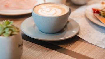 A cup of coffee with latte art on a saucer.